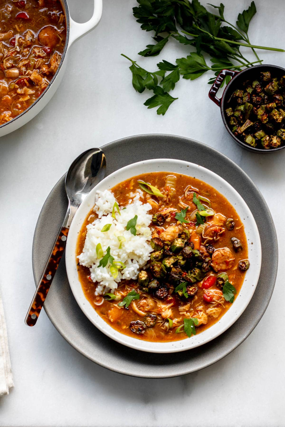 bowl of gluten free chicken and sausage gumbo with parsley in the background