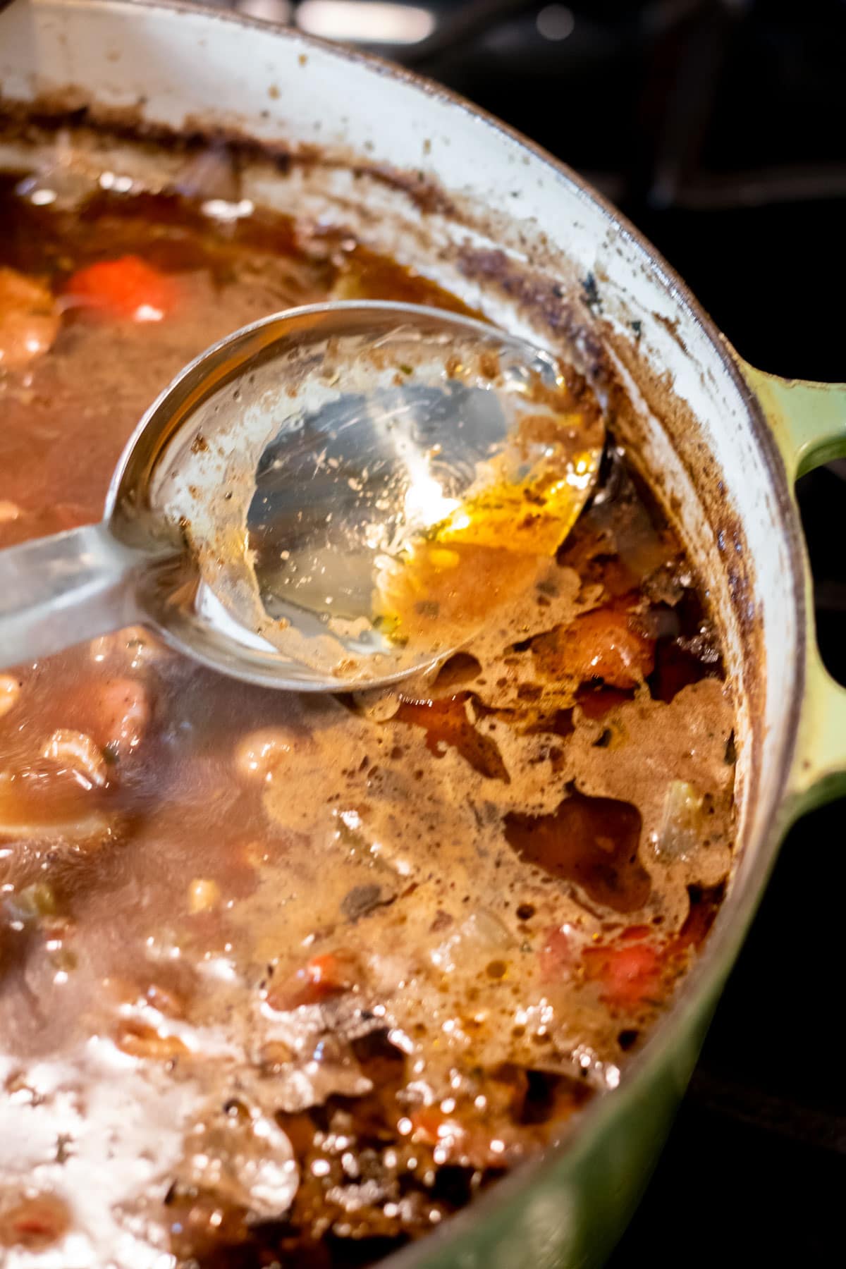 skimming fat from a pot of gumbo