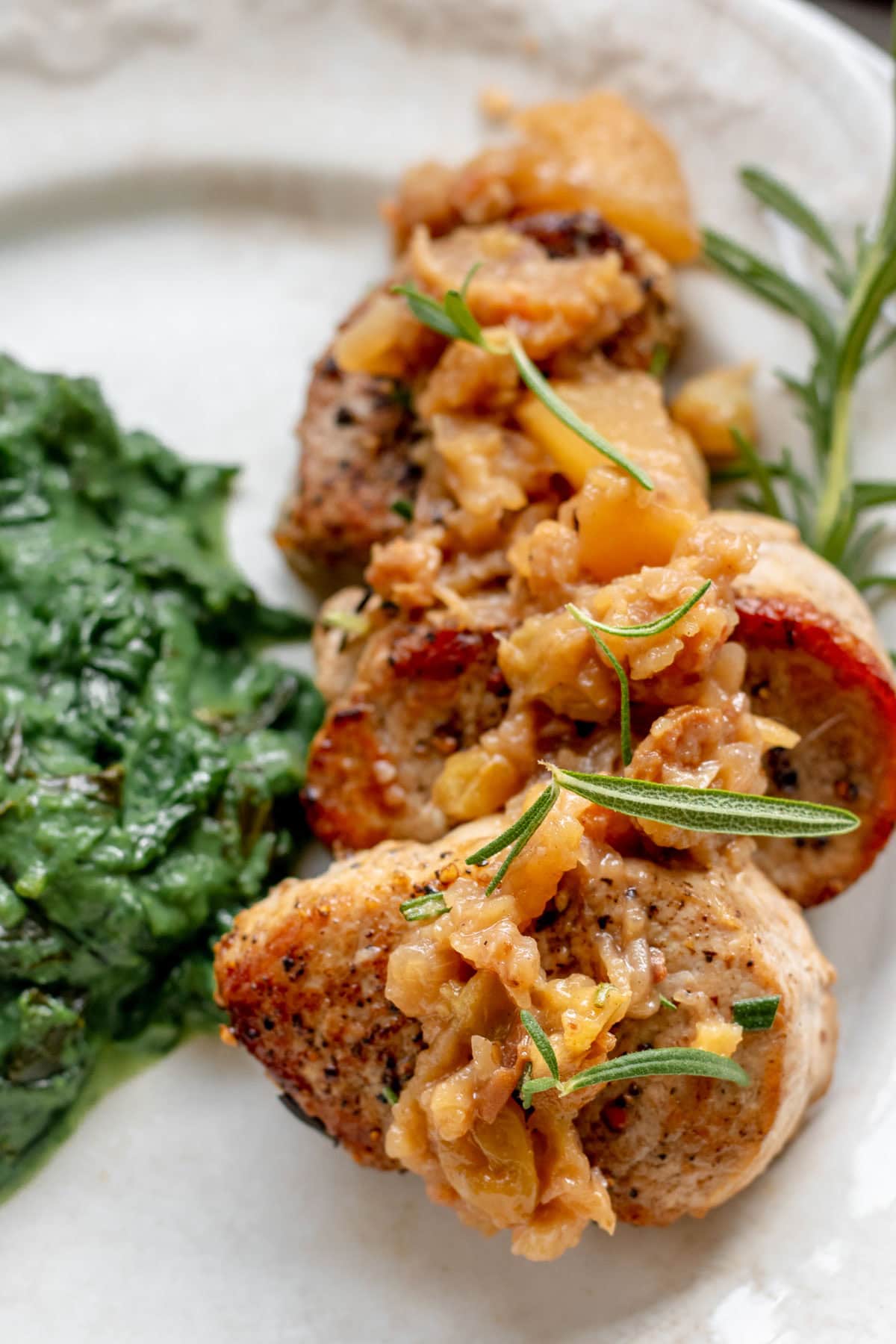 pork medallions on a plate with apple chutney and creamed greens