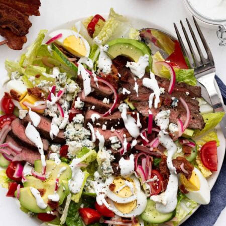 a large bowl of steak cobb salad with a fork