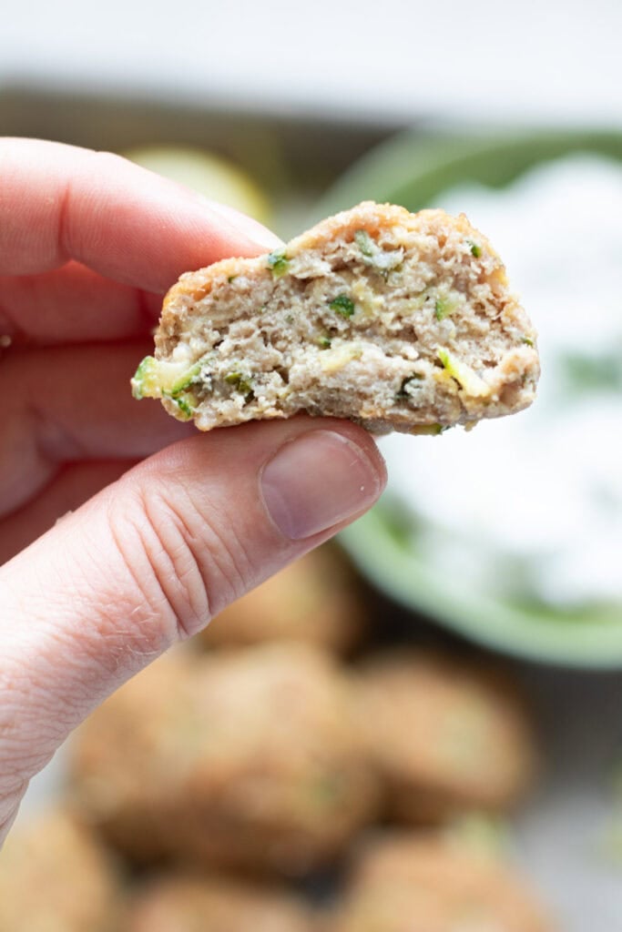 hand holding half a turkey zucchini meatball