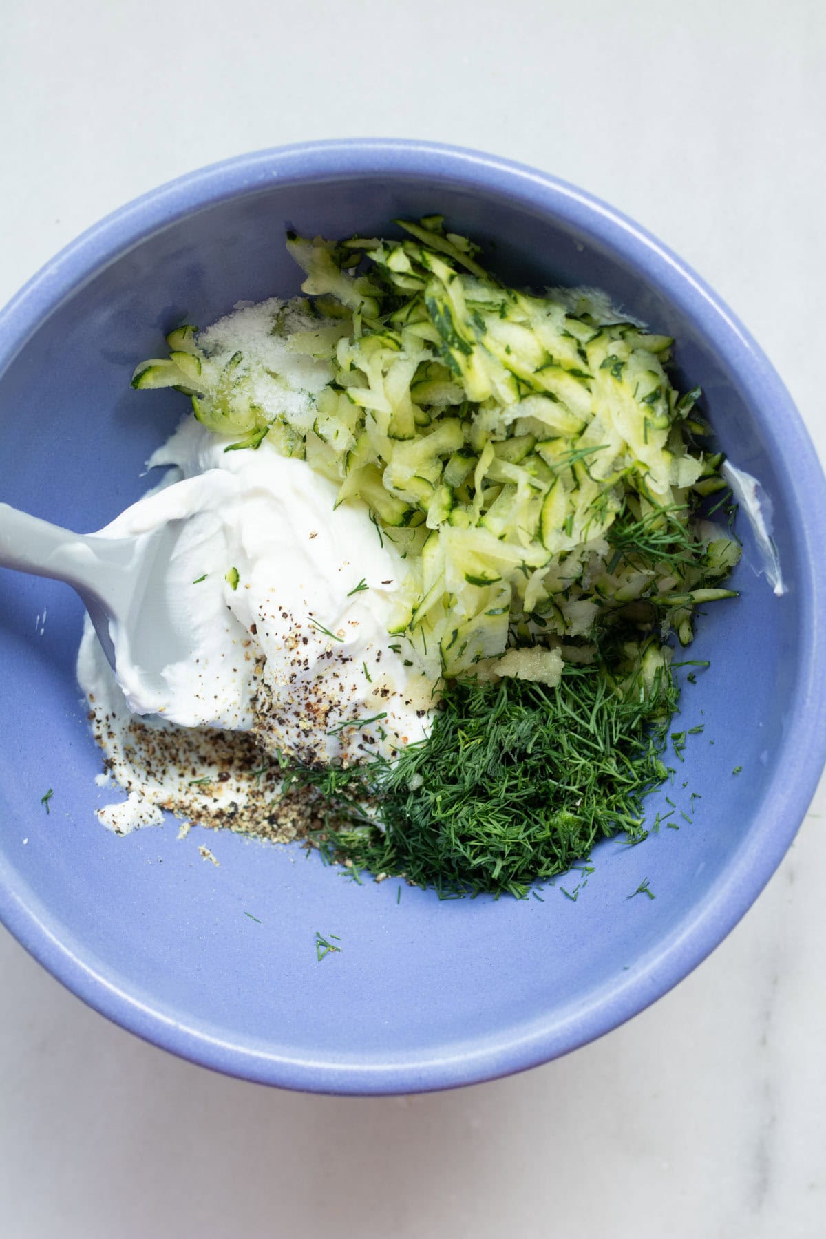 large bowl of zucchini tzatziki not yet stirred together