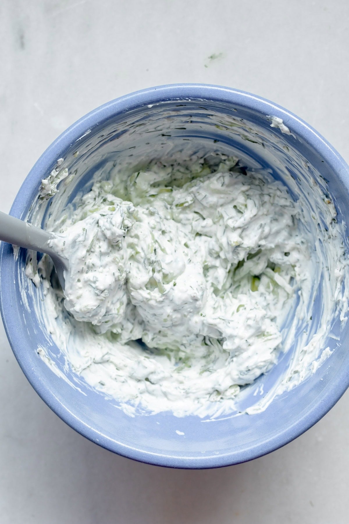 large bowl of stirred together zucchini tzatziki