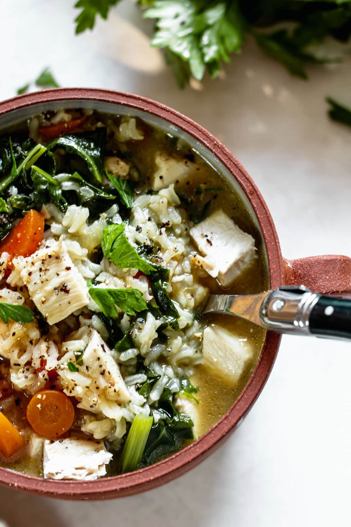 a bowl of chicken rice soup with a spoon inside