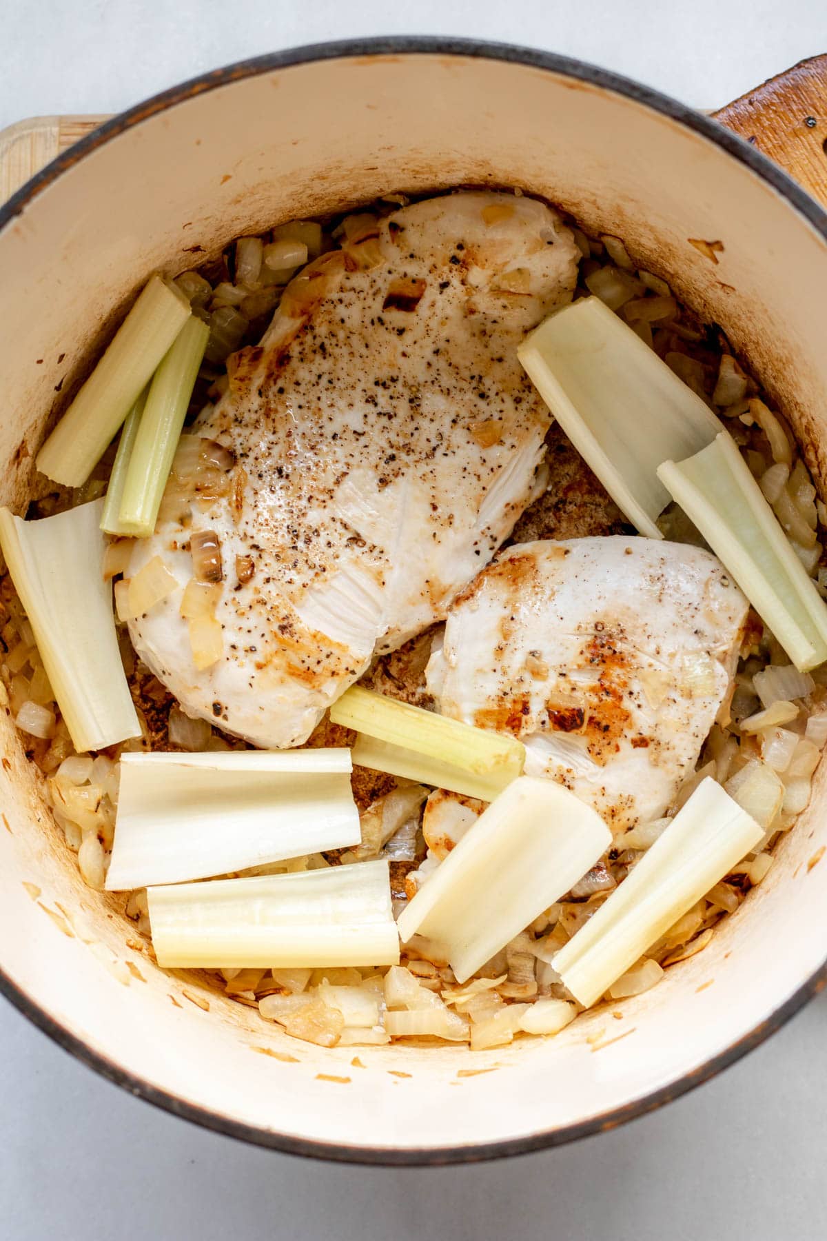 searing chicken and celery in a pot for soup