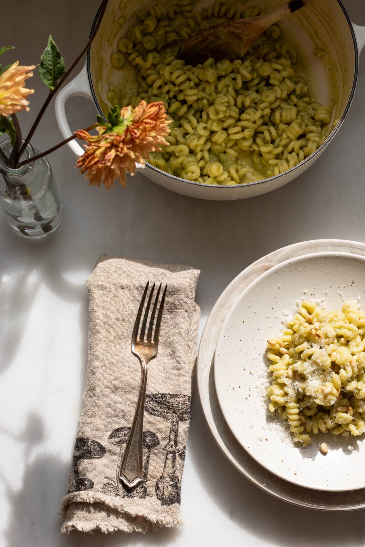 plate of creamy zucchini pasta with a pot in the background