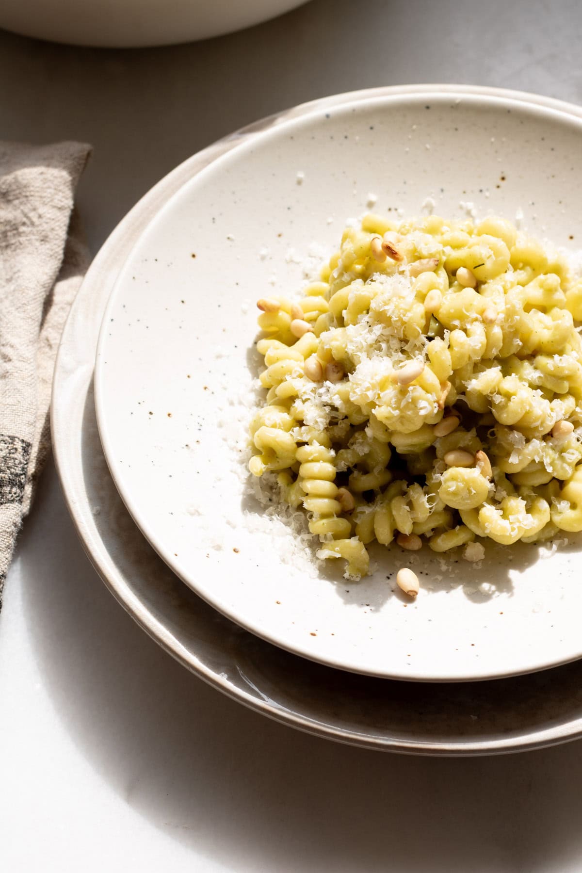 white plate with creamy zucchini pasta