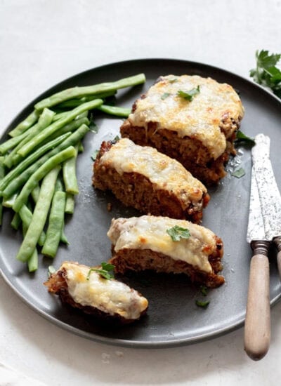 plate of meatloaf with knives and green beans