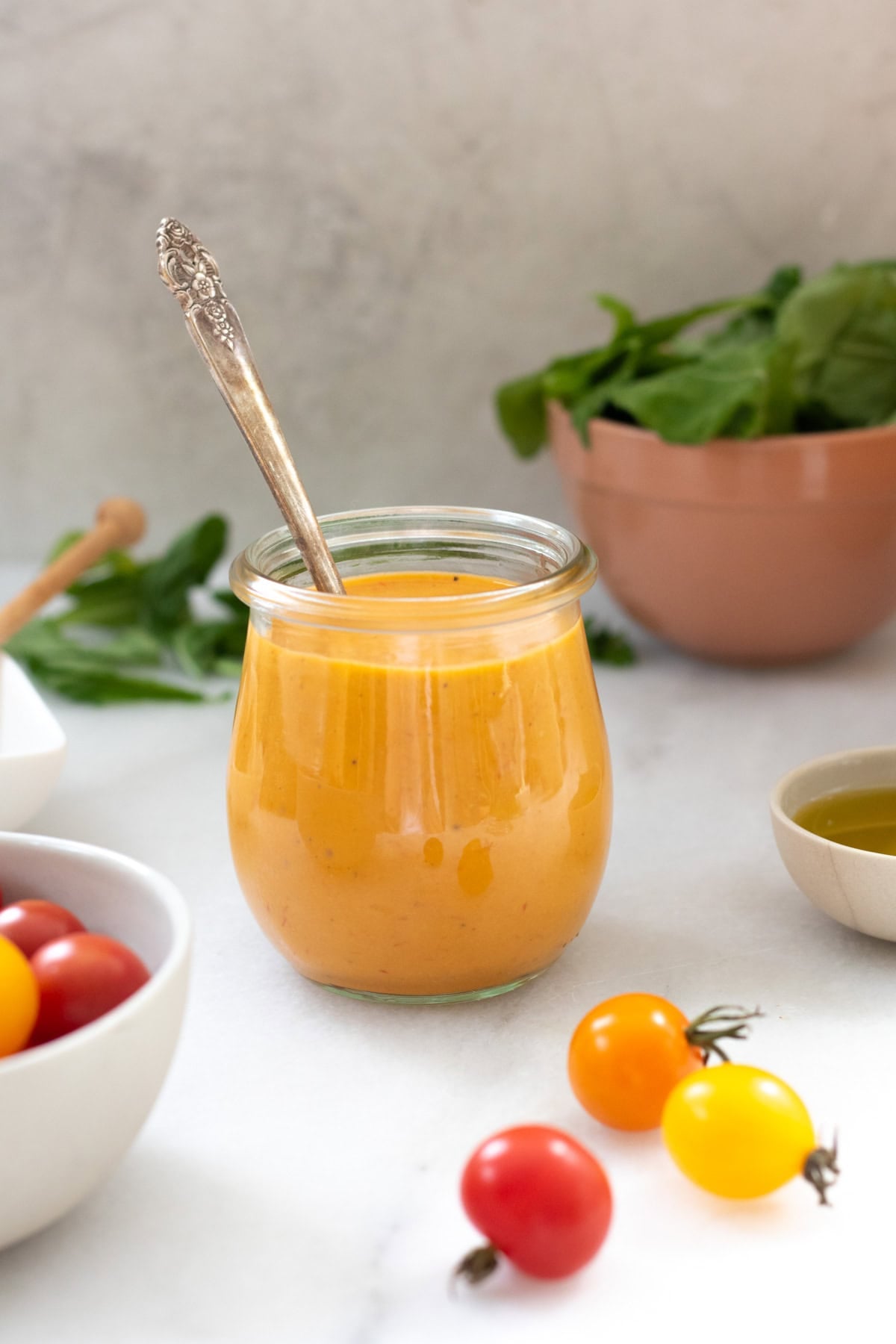 tomato vinaigrette in a small jar next to cherry tomatoes