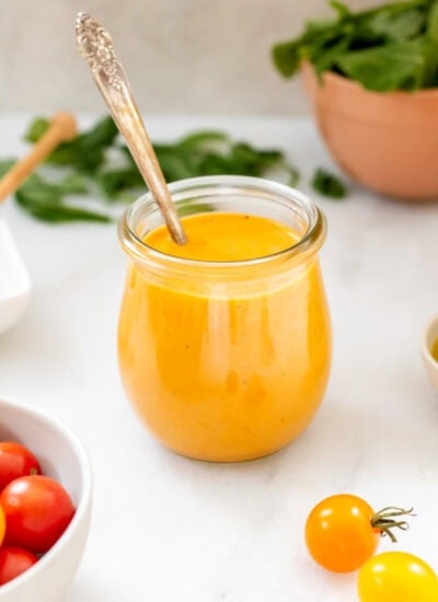 tomato vinaigrette in a small jar next to cherry tomatoes