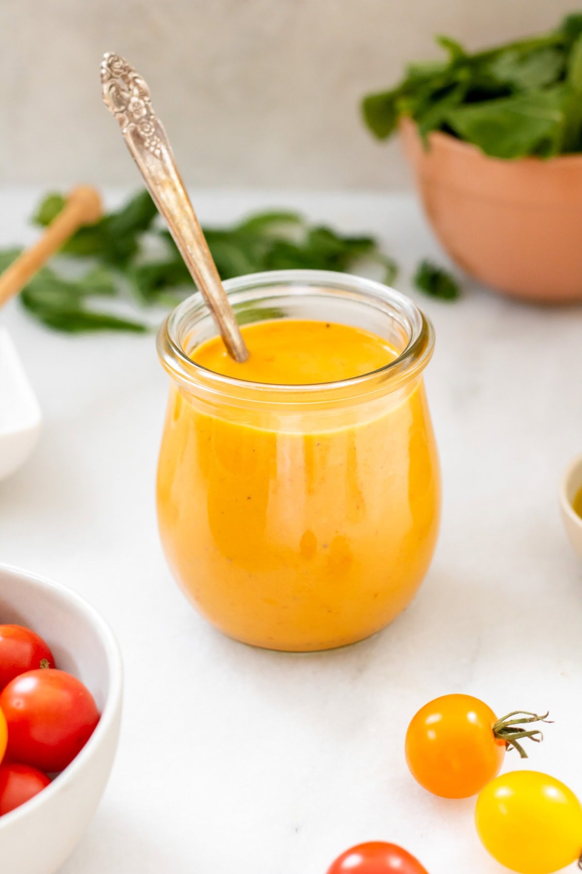tomato vinaigrette in a small jar next to cherry tomatoes