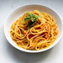 large bowl of sungold tomato pasta with basil