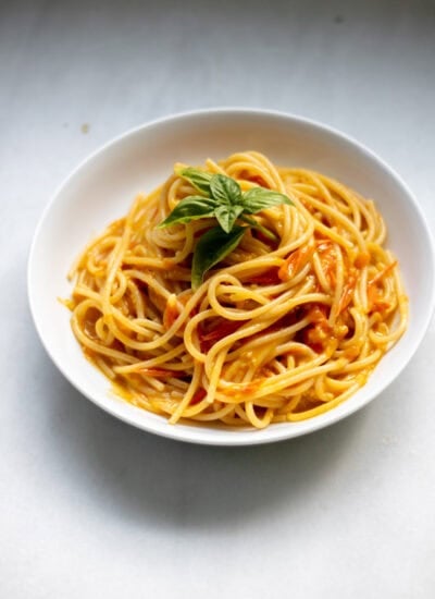 large bowl of sungold tomato pasta with basil