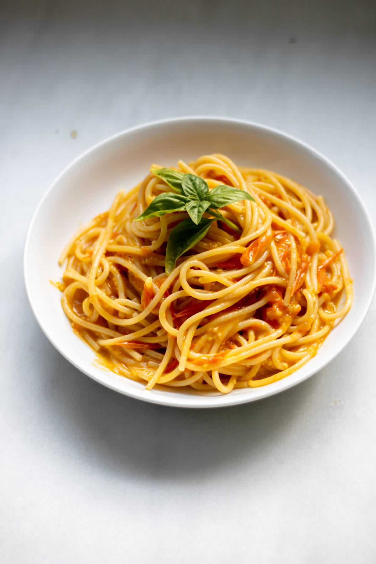 large bowl of sungold tomato pasta with basil
