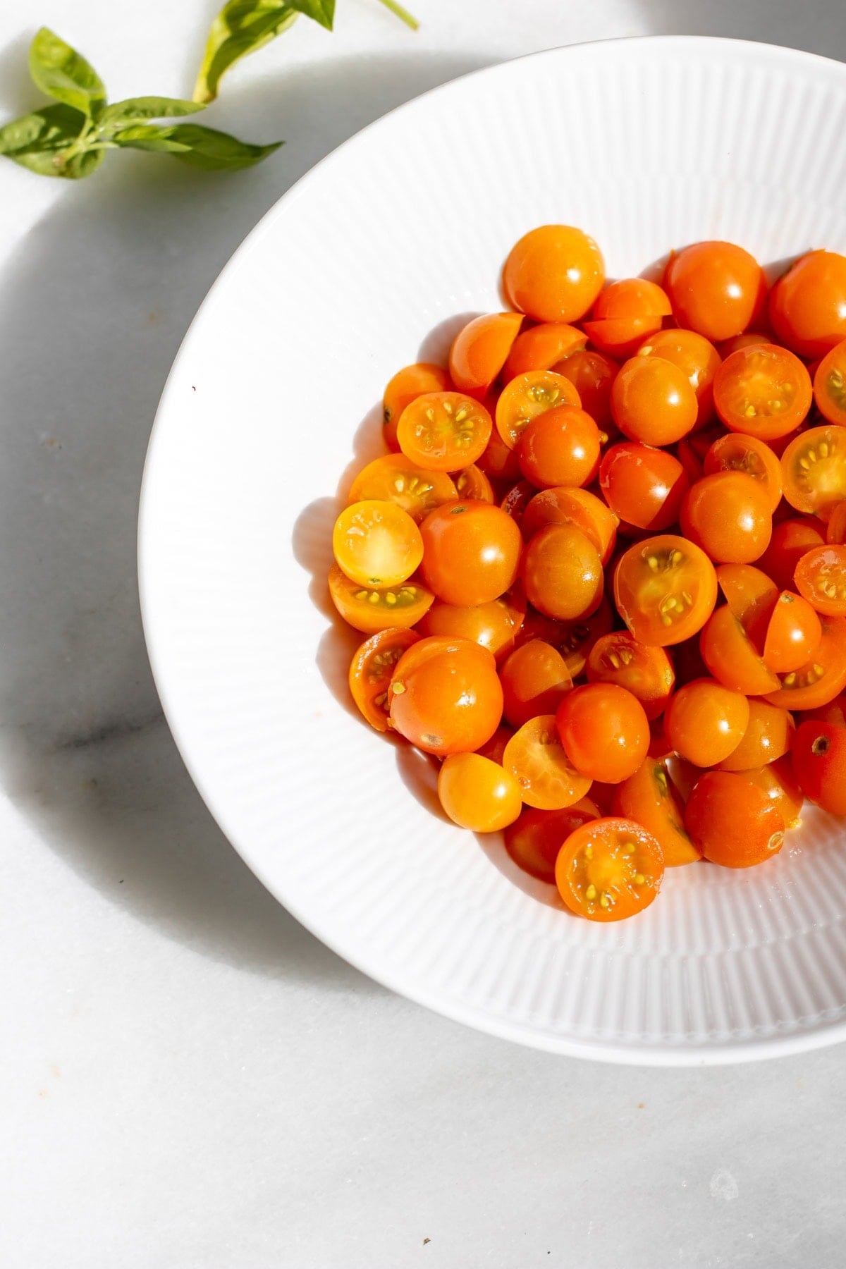 a bowl of sungold tomatoes cut in half