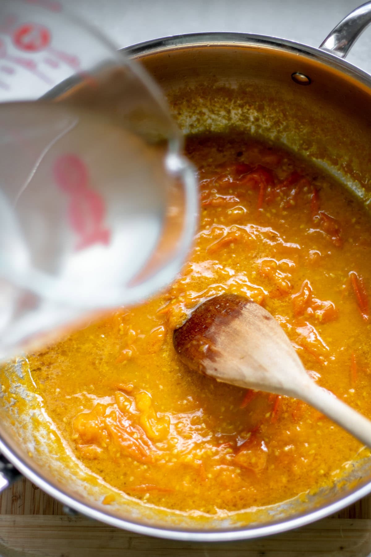 pasta water added to a pot of sungold tomato sauce