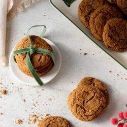 stack of molasses cookies tied up with a ribbon and more cookies in the foreground and background