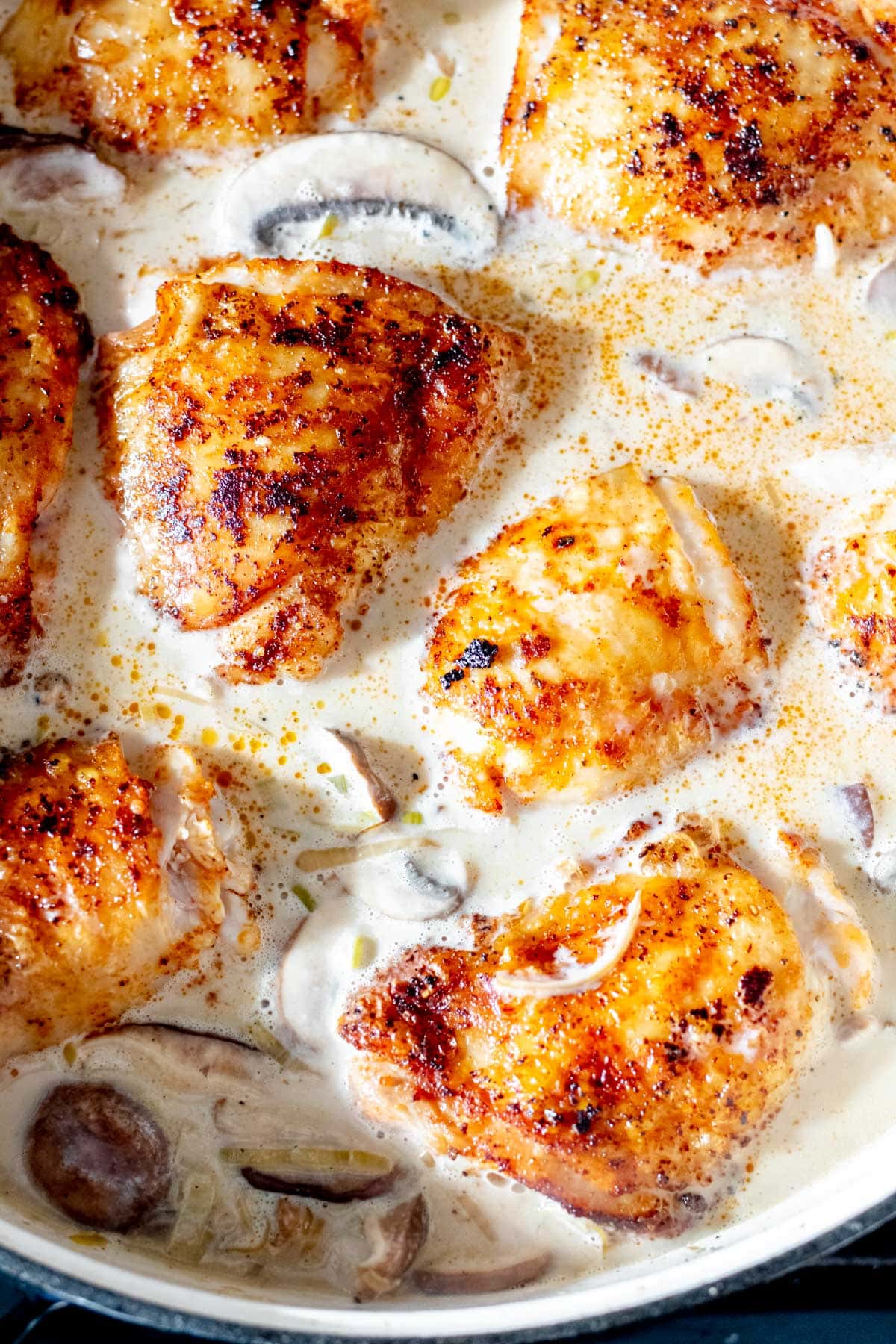 seasoned chicken breasts simmering in sauce