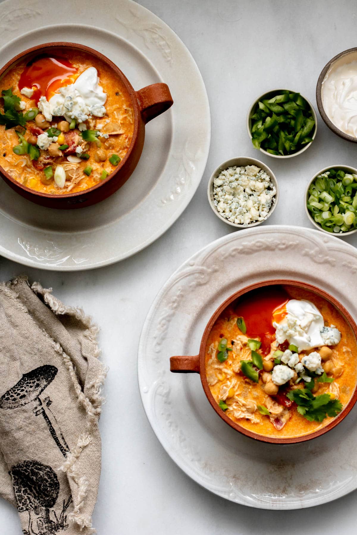 2 servings of Buffalo Chicken Chili in a brown bowl on a white plate