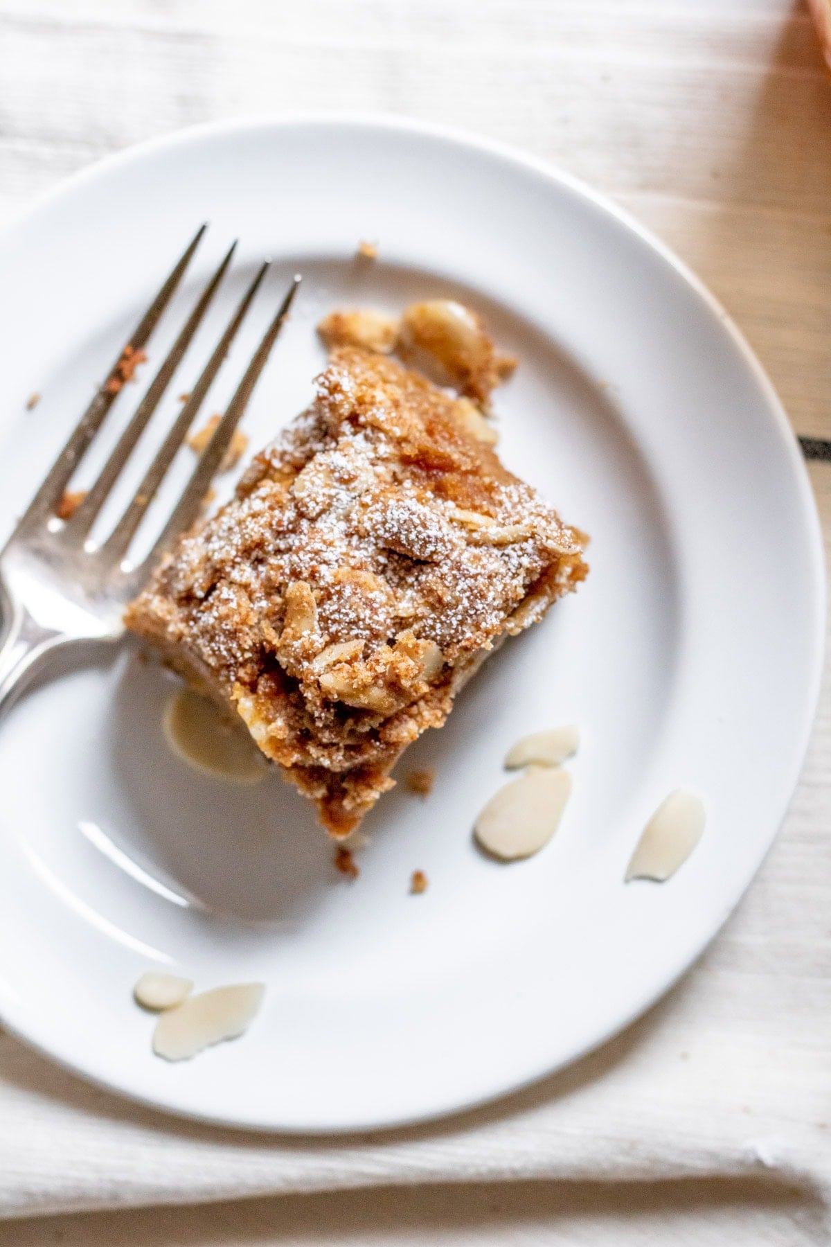 a single slice of Apricot Almond Coffee Cake on a small white plate with a fork