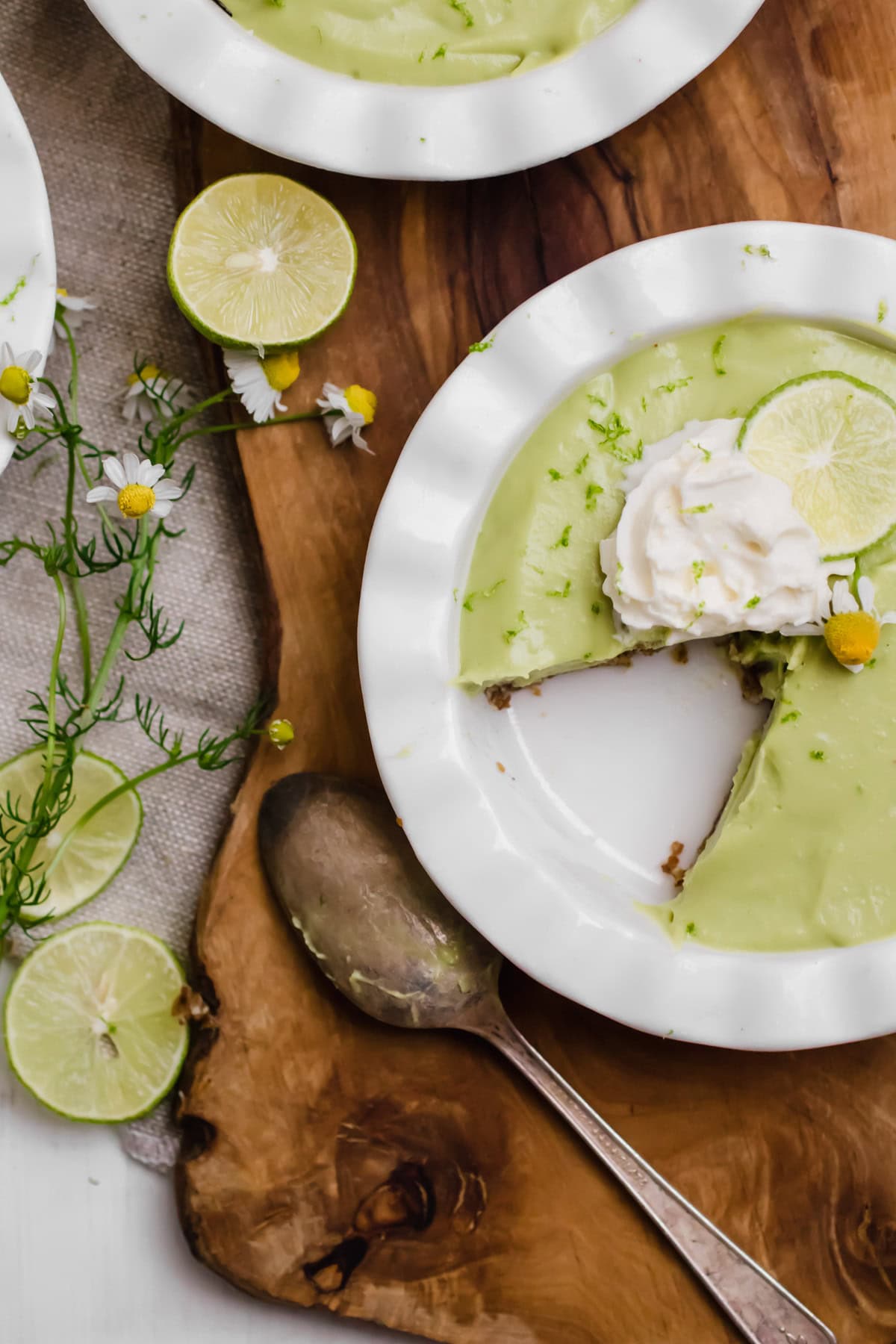avocado key lime pie with on a brown board with cutlery