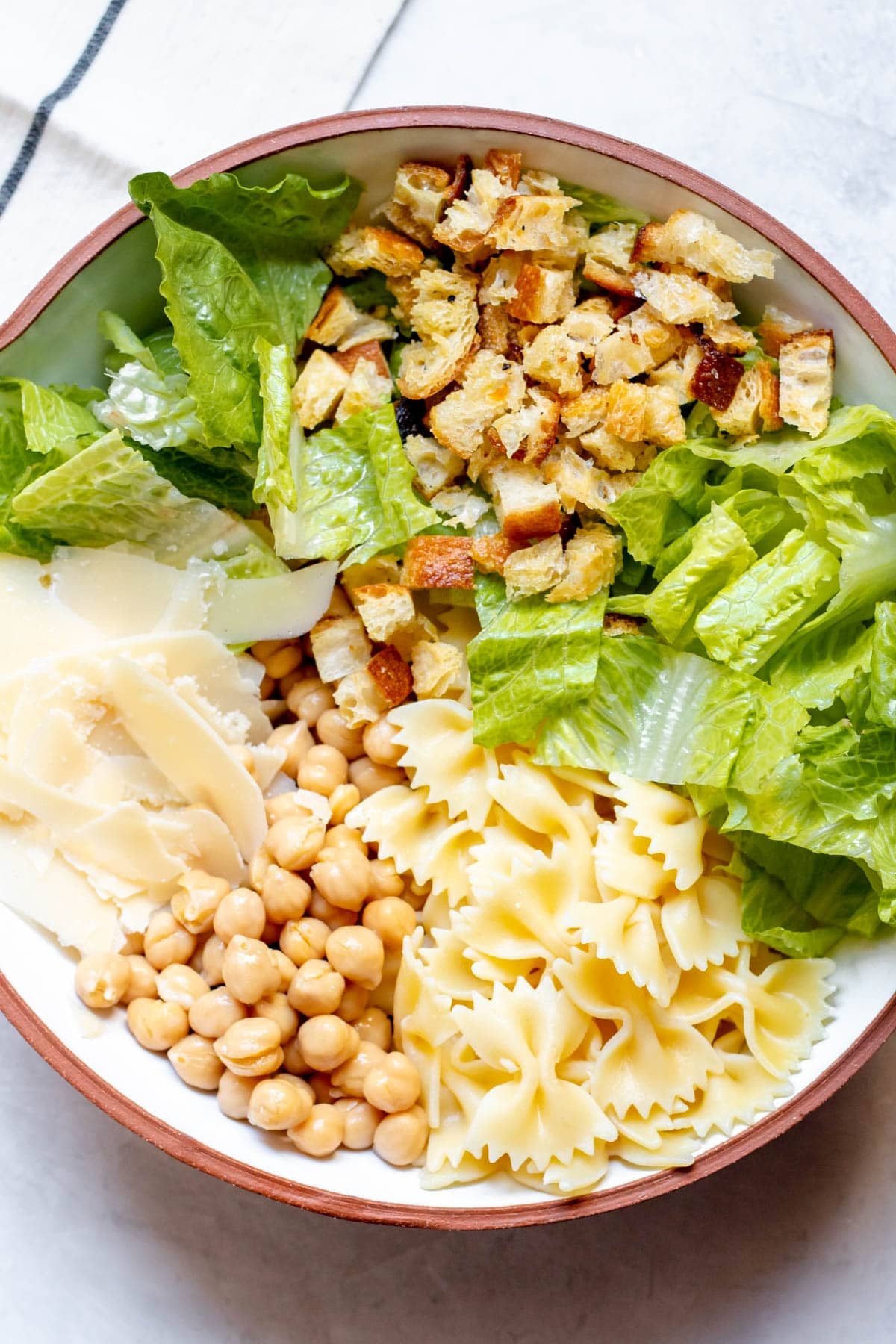 ingredients in a bowl for Chickpea Caesar Pasta Salad