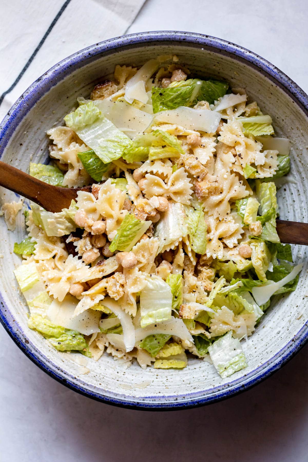 Chickpea Caesar Pasta Salad in a purple bowl with two salad spoons