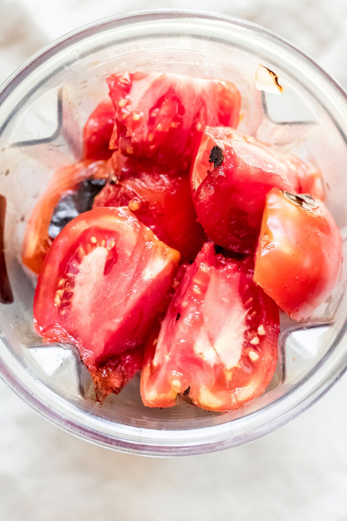 top down view of charred tomatoes in a blender