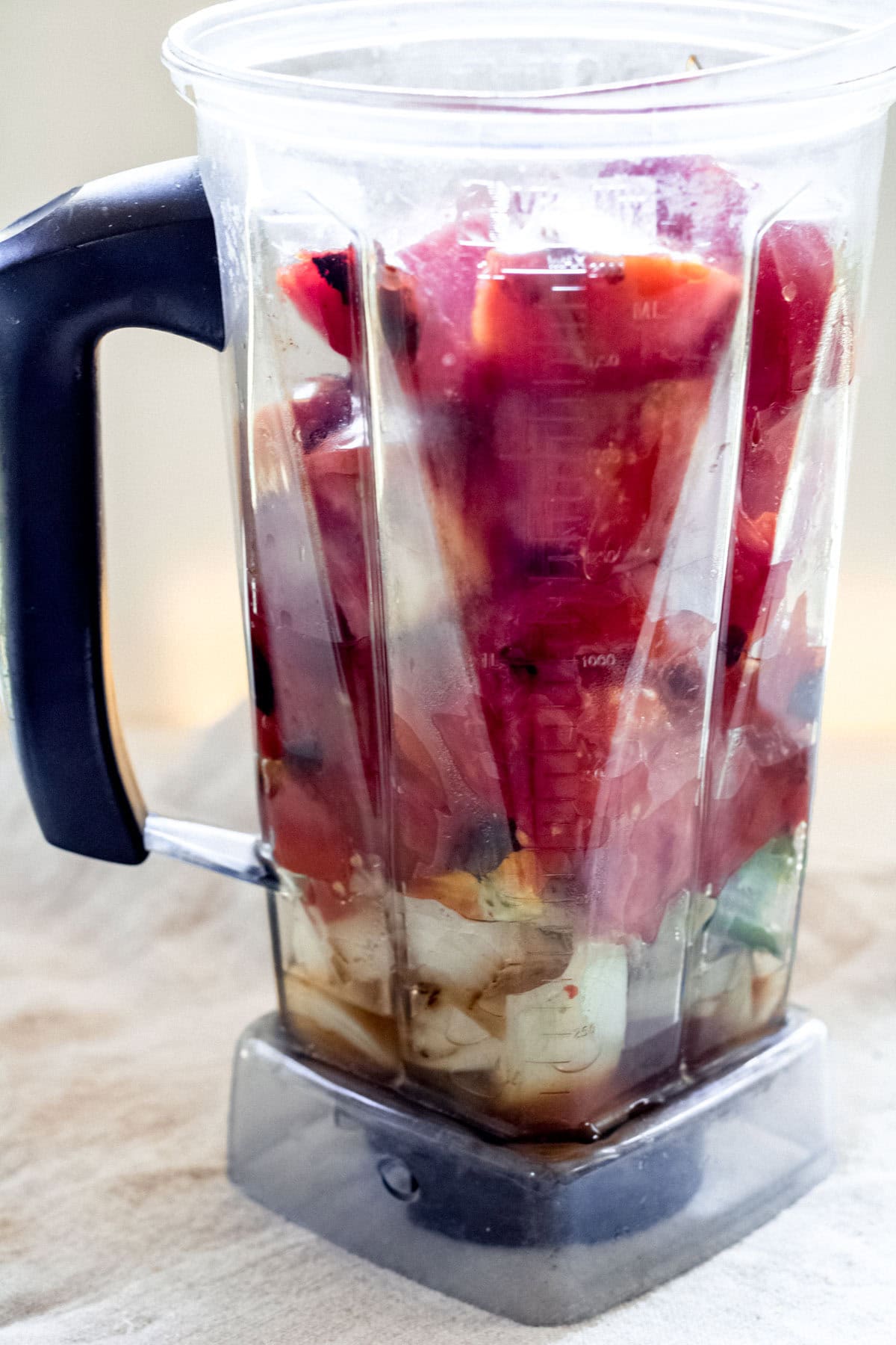 charred tomatoes and other ingredients in a blender
