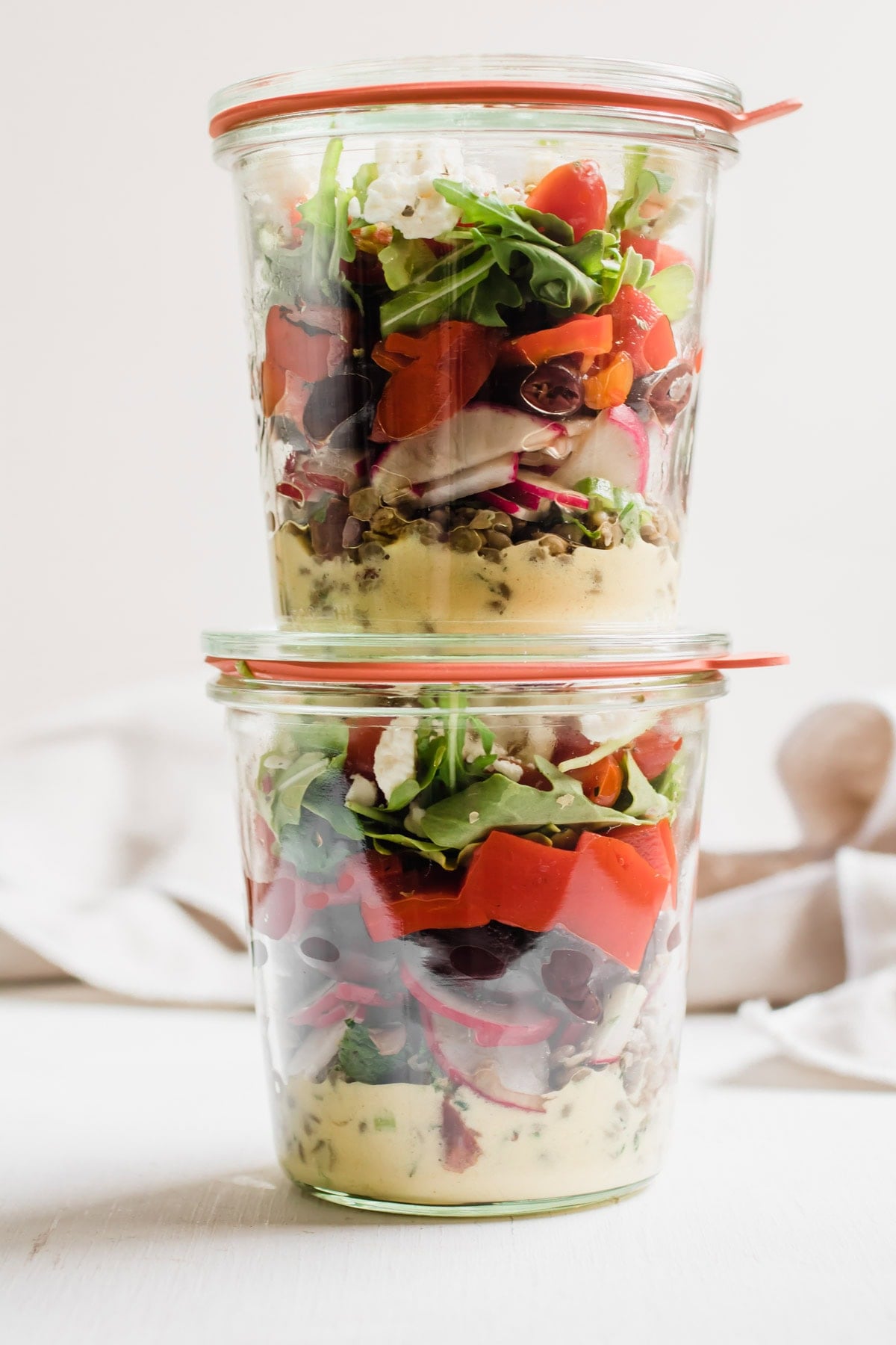 Two jars of greek lentil salad on top of each other