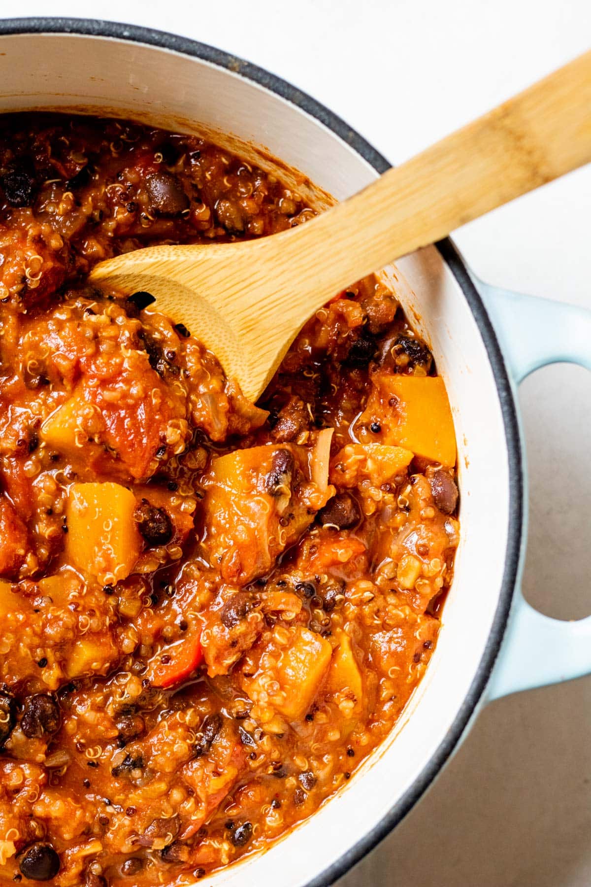 stirring chili in a white pot