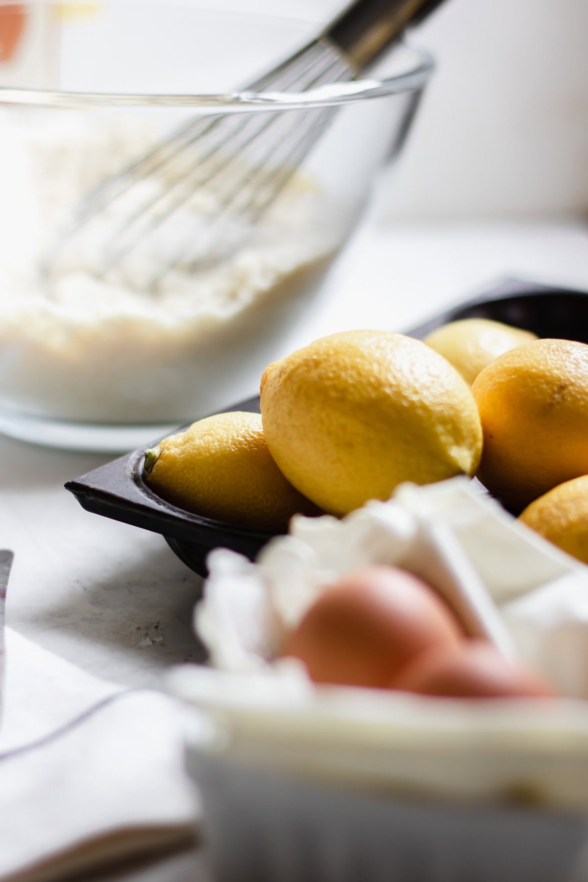 close up of eggs, lemons and flour in a bowl