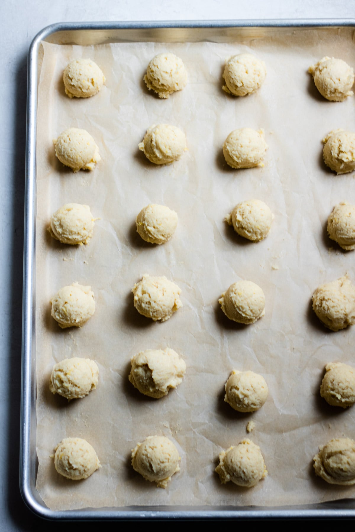 raw cookie dough balls on a sheet pan