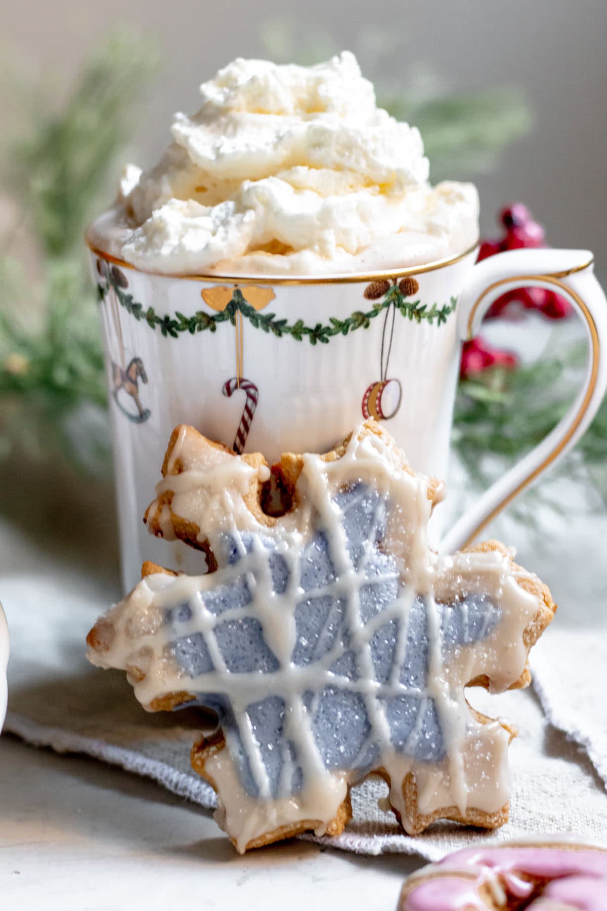 an almond flour sugar cookie in front of a cup of hot chocolate