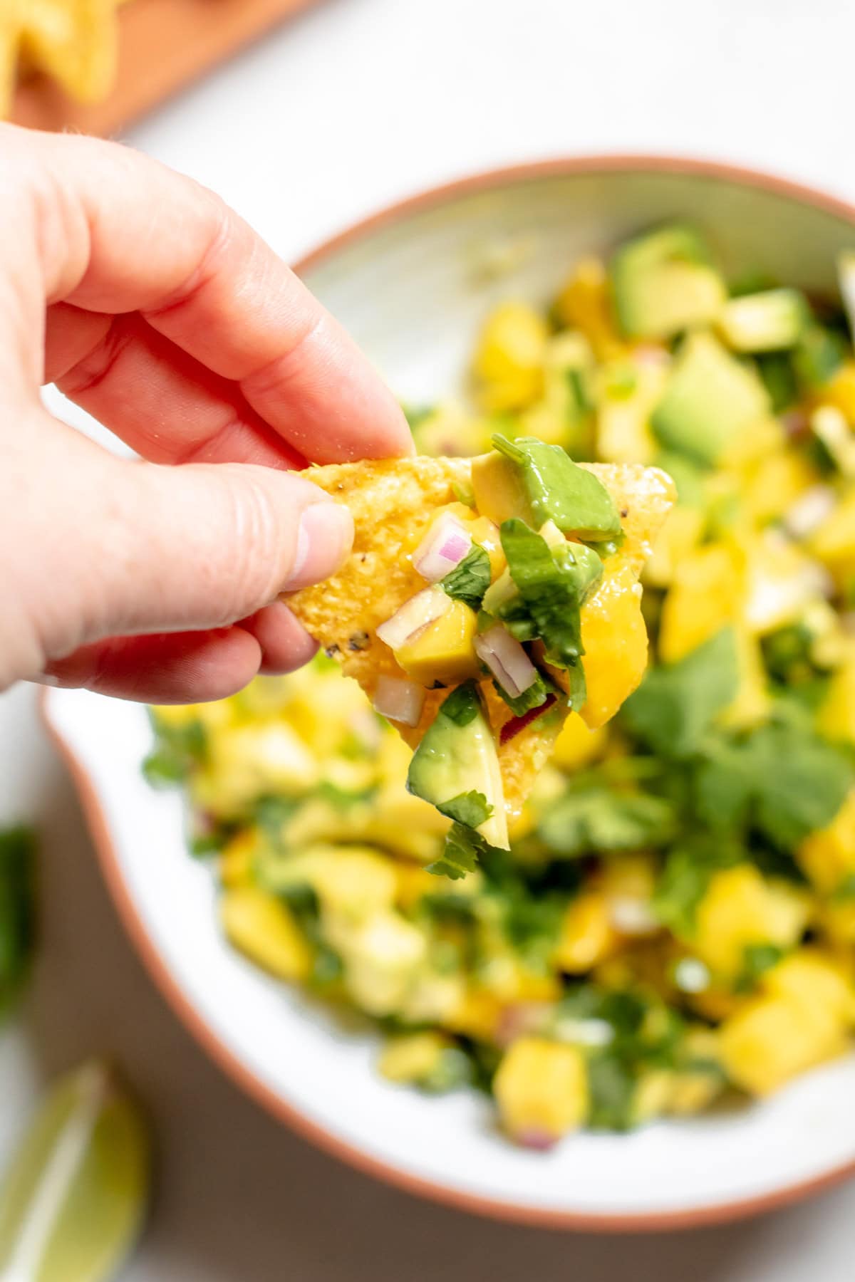 dipping tortilla chip into salsa