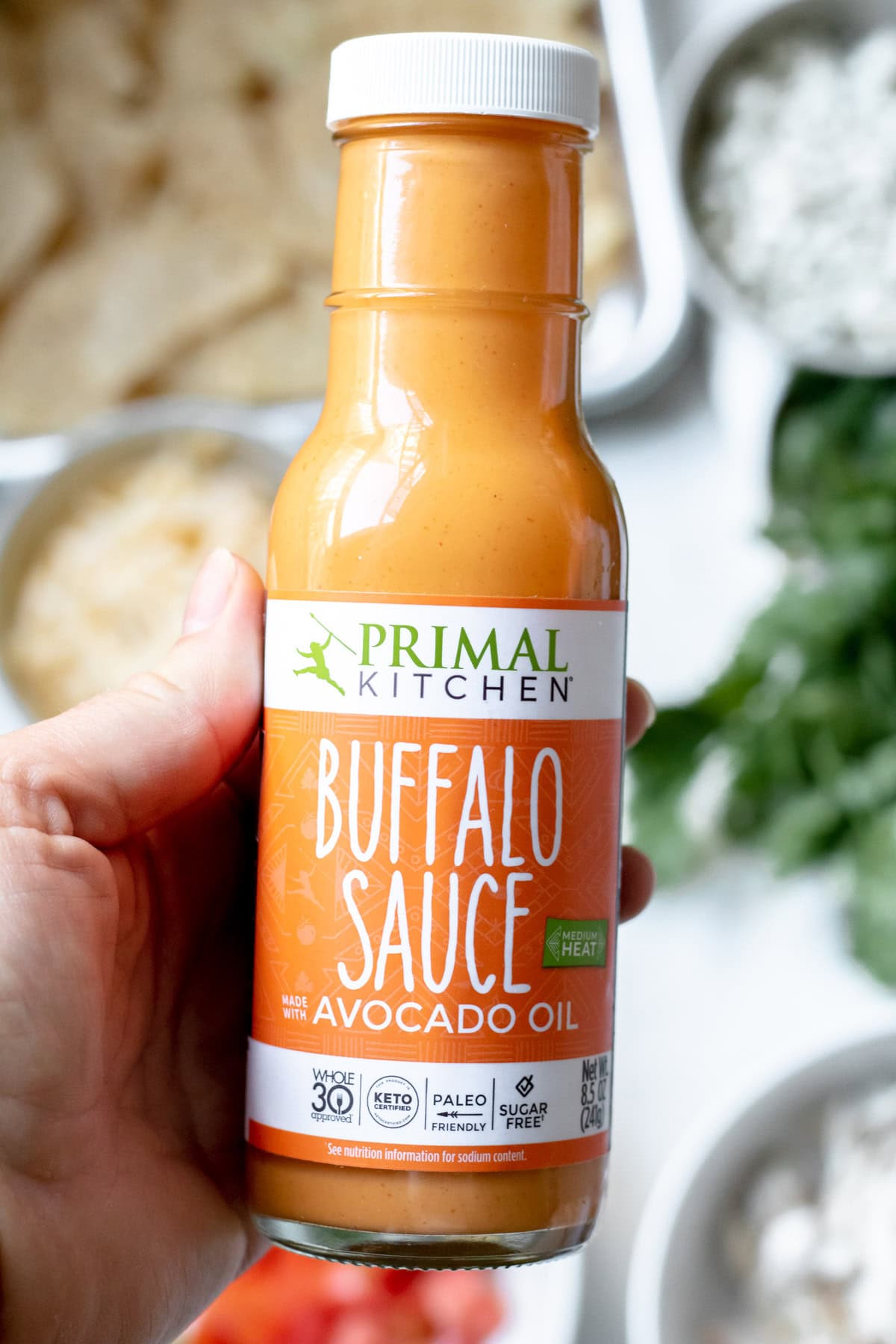 a glass bottle of store-bought buffalo sauce