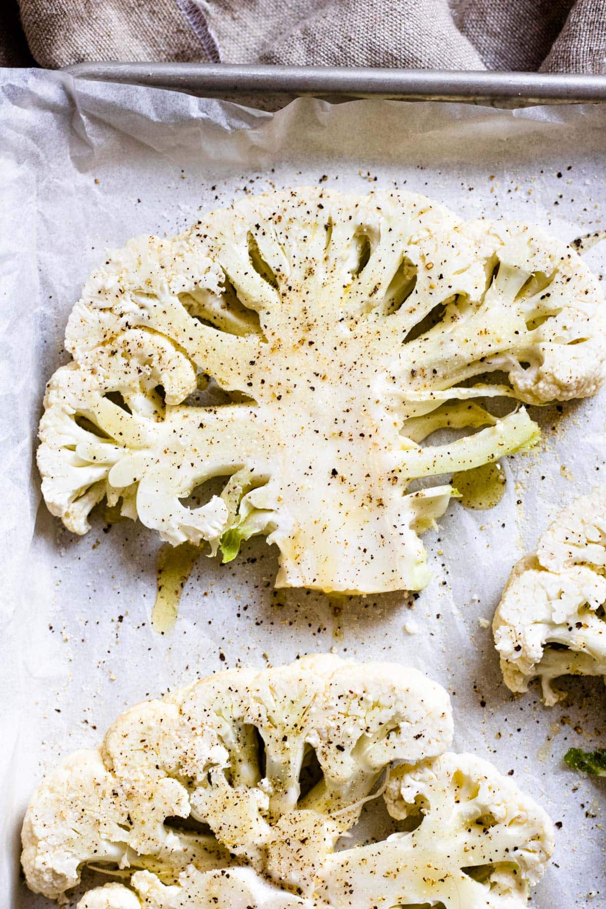 seasoned cauliflower slices on a baking tray