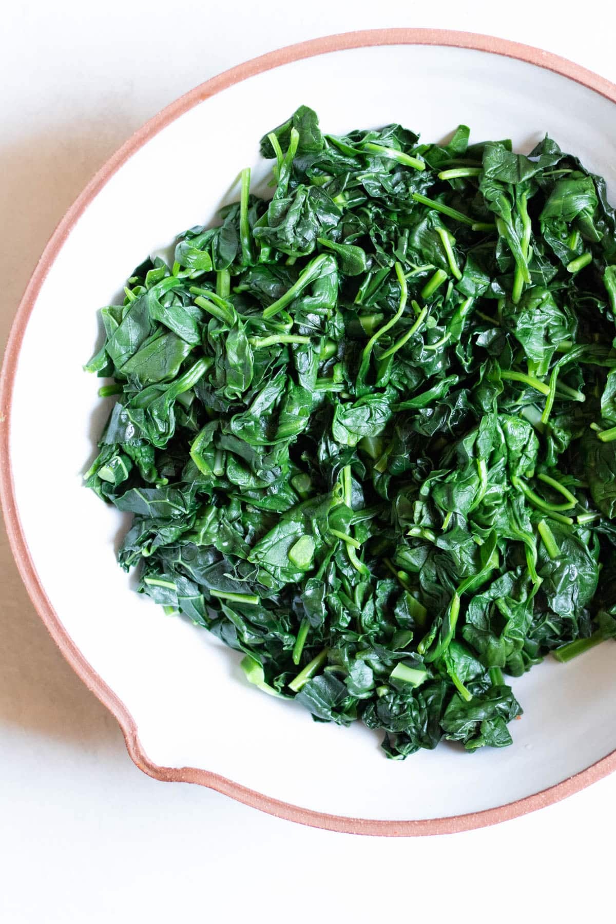 boiled kale and spinach leaves in a bowl