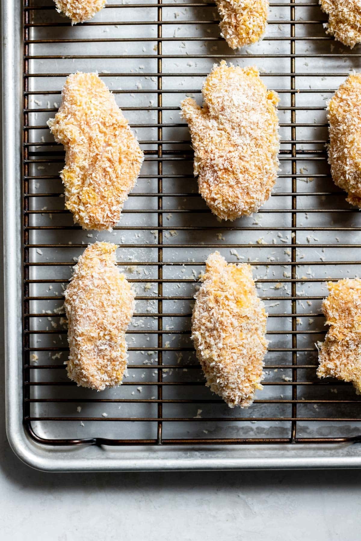 breaded chicken slices on a wire rack