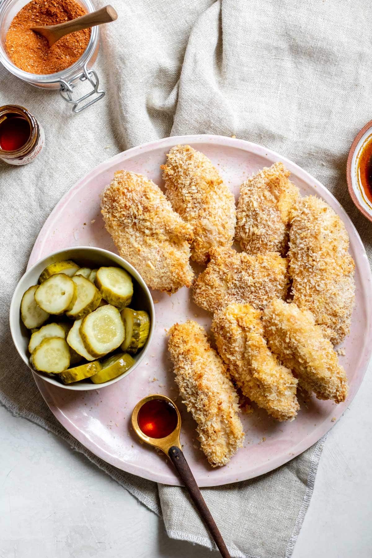 Oven Baked Nashville Hot Chicken Tenders with sliced pickles on the side