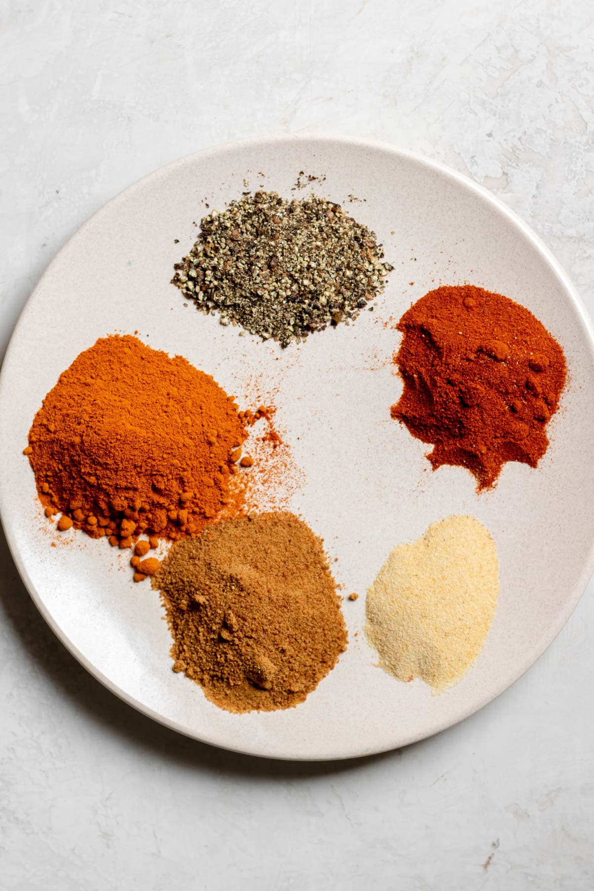 ingredients needed for chicken spice mix on a plate