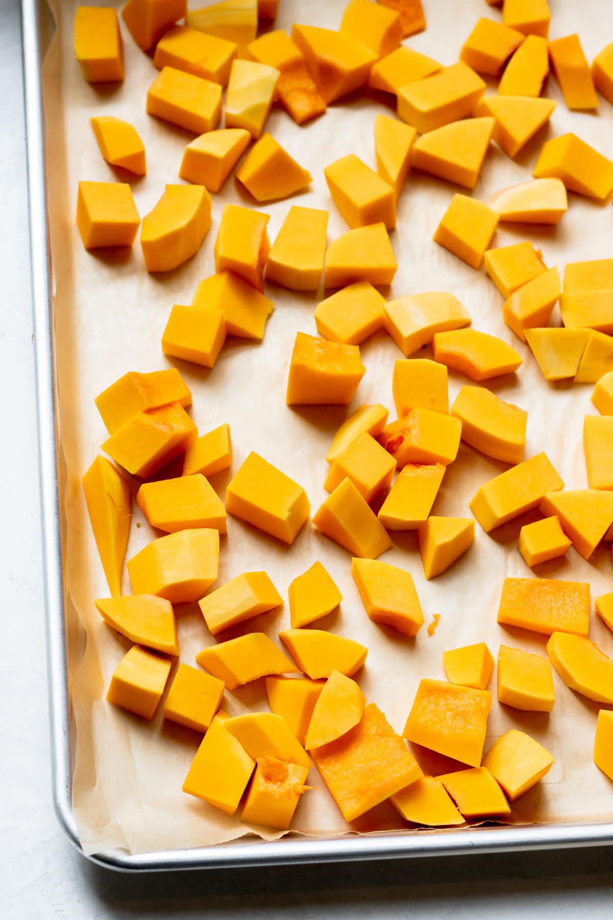 cubed butternut squash on a baking sheet