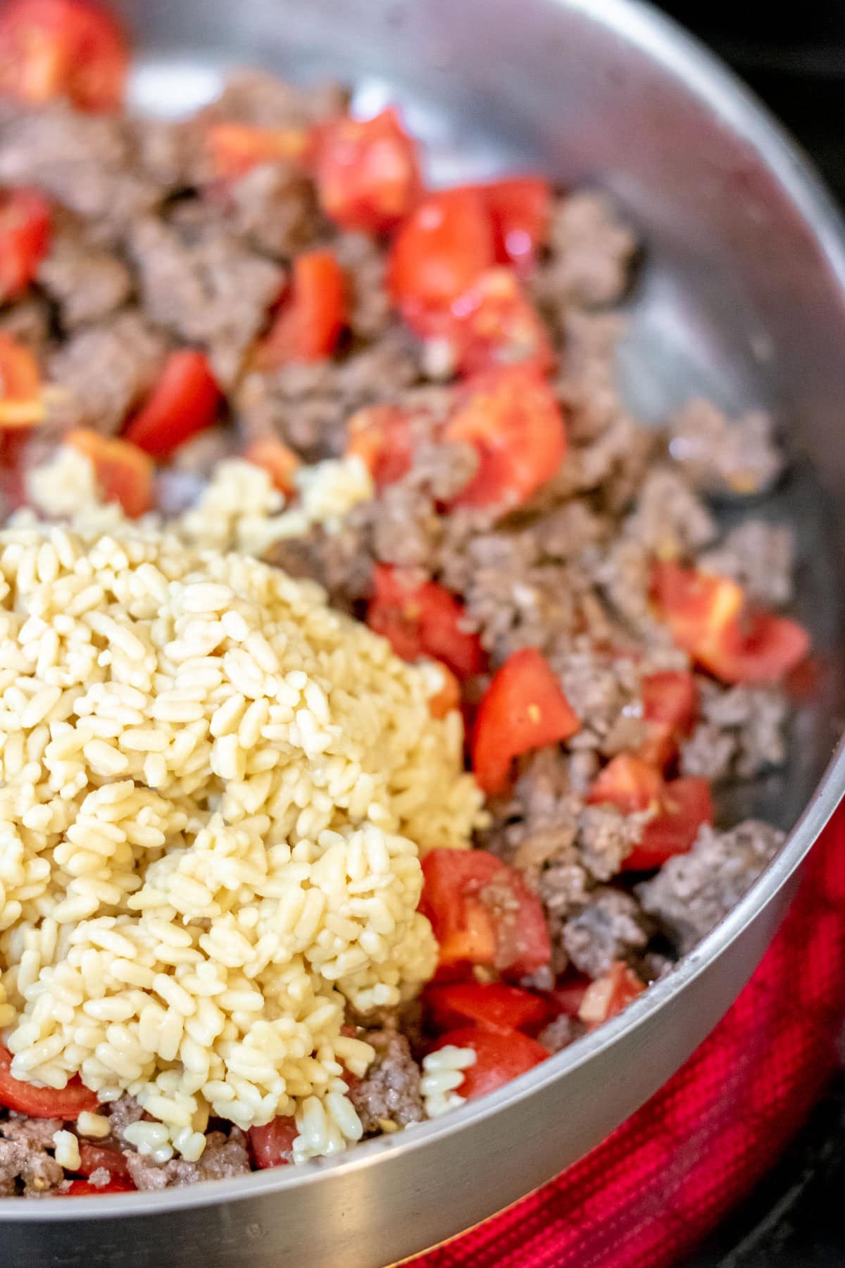 rice, tomatoes, and ground beef in a pan