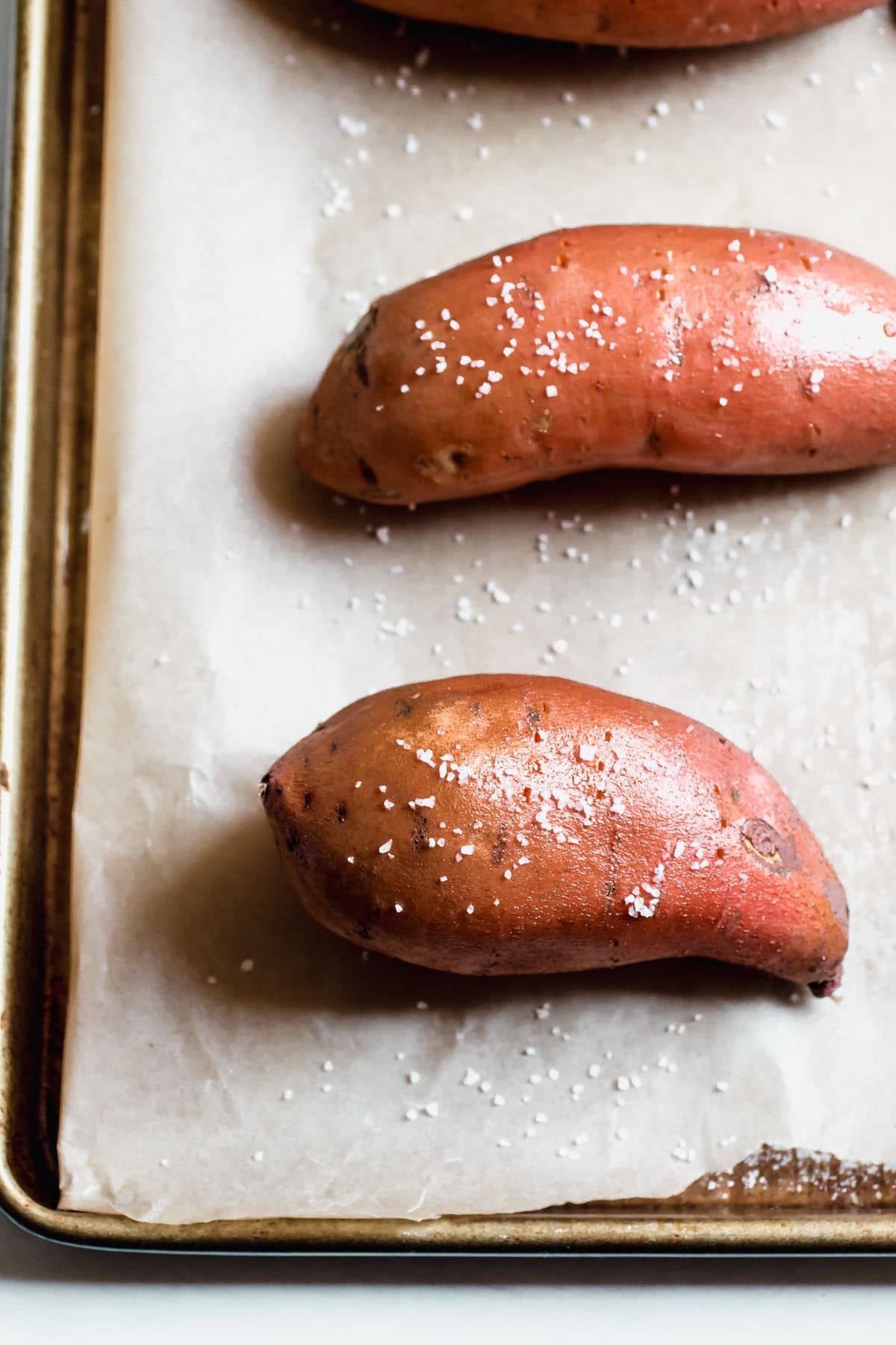 whole sweet potatoes on a baking sheet