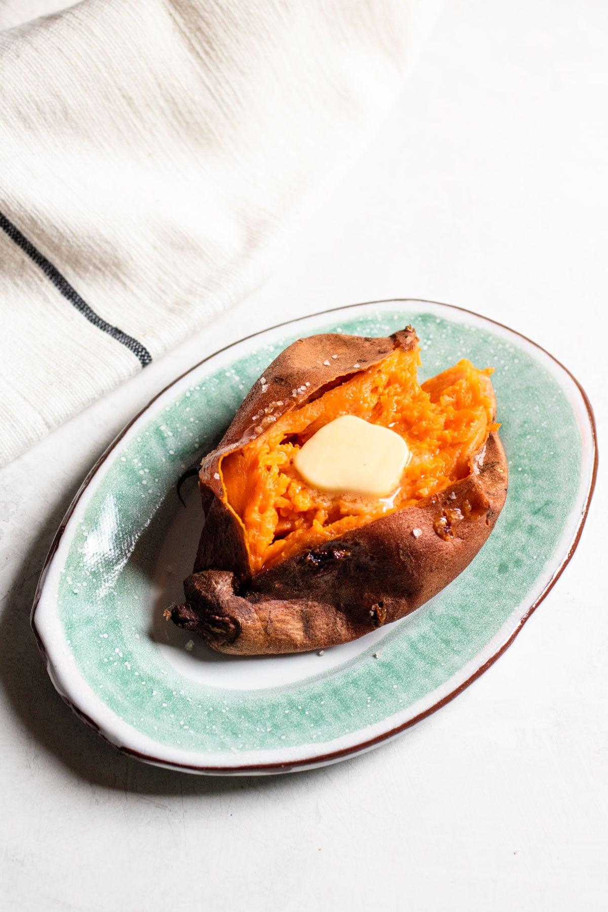 halved sweet potato with a piece of butter inside