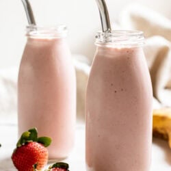 two glass bottles of strawberry banana adaptogen smoothie