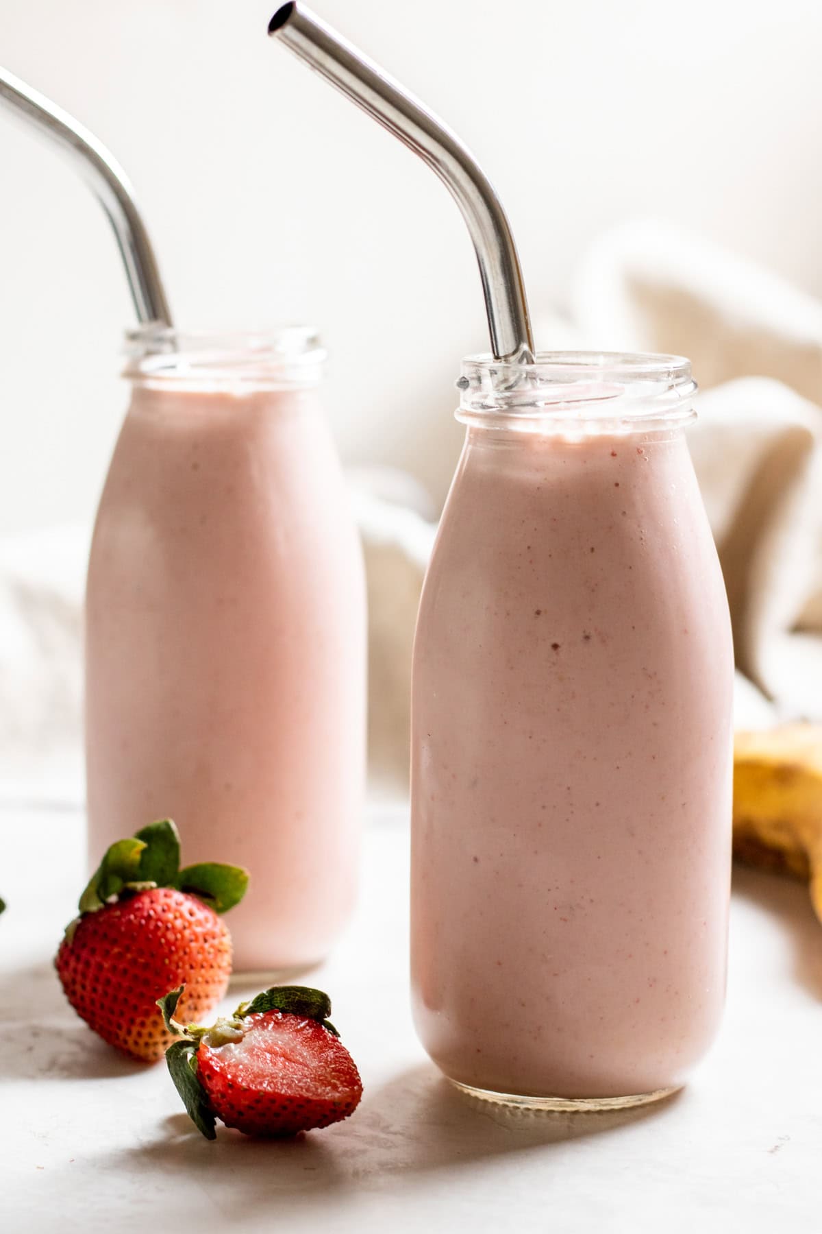 two glass bottles of strawberry banana adaptogen smoothie