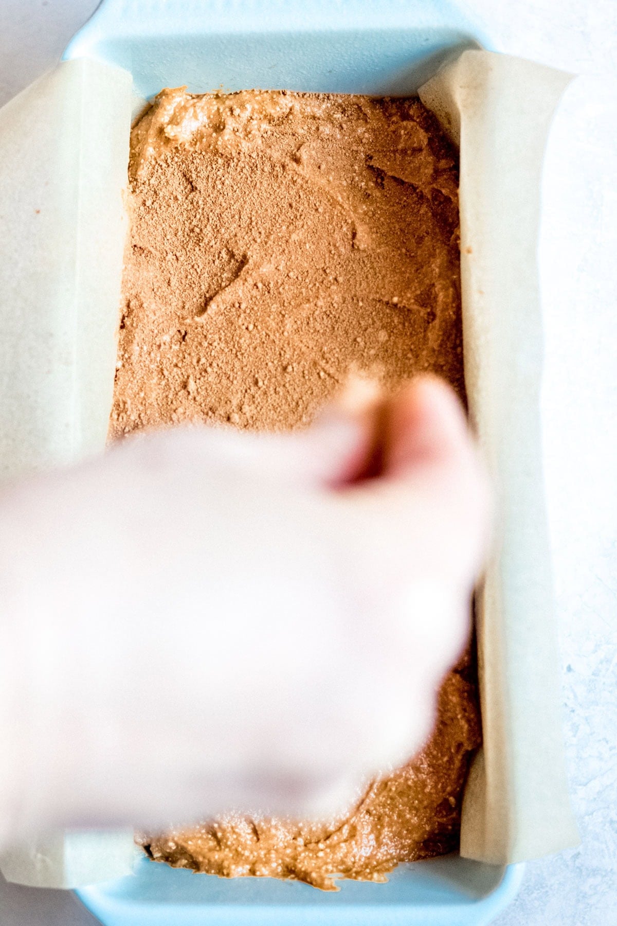 sprinkling cinnamon sugar on top of dough