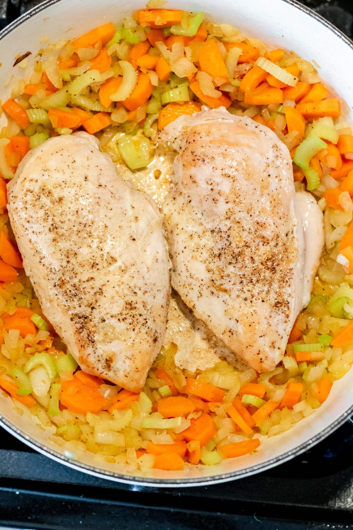 adding chicken breasts to sauteed veggies