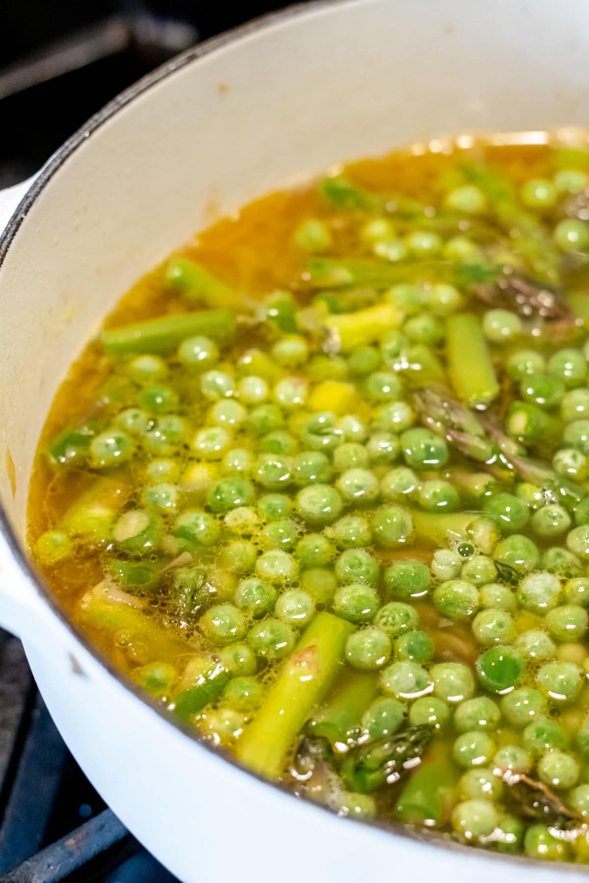 green peas and asparagus cooking in the pot